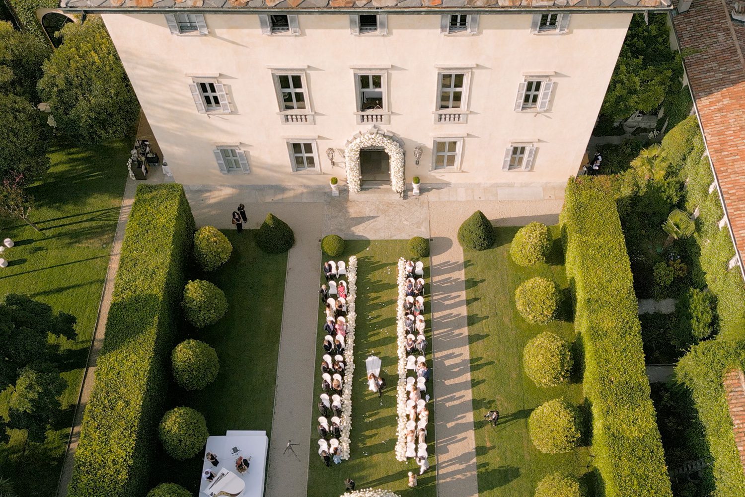 Aerial drone shot of the bride walking down the aisle during the ceremony at Villa Balbiano, Lake Como — captured by Koman Studio, fine-art wedding photographers and filmmakers in Italy.