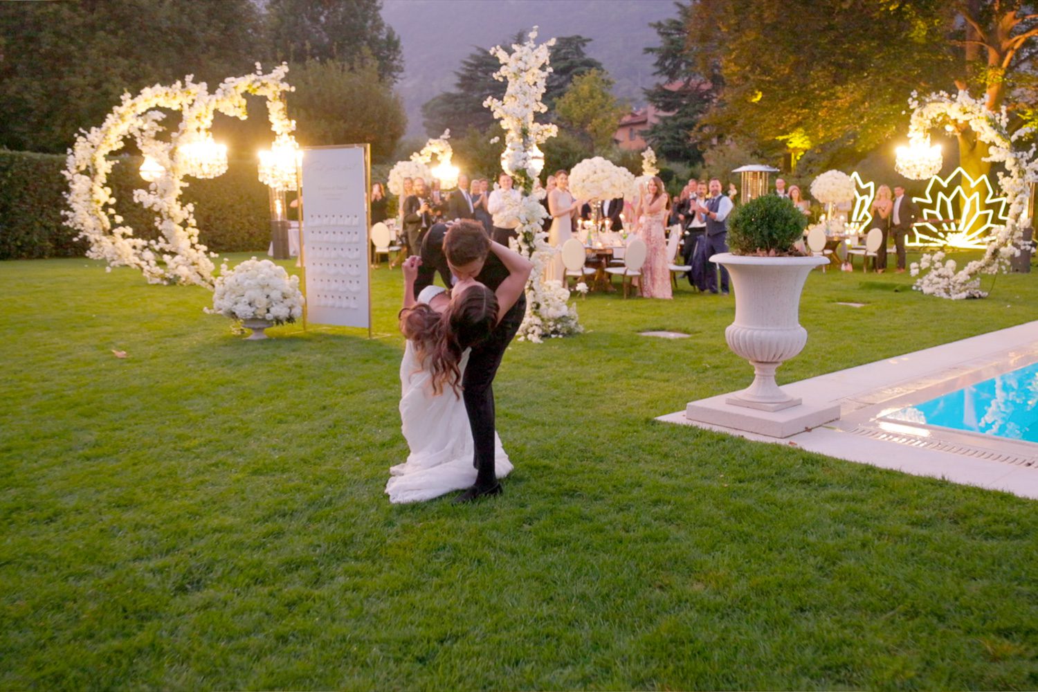 Bride and groom share a kiss by the grand entrance of Villa Balbiano during their wedding reception on Lake Como — captured by Koman Studio, fine-art wedding photographers in Italy.