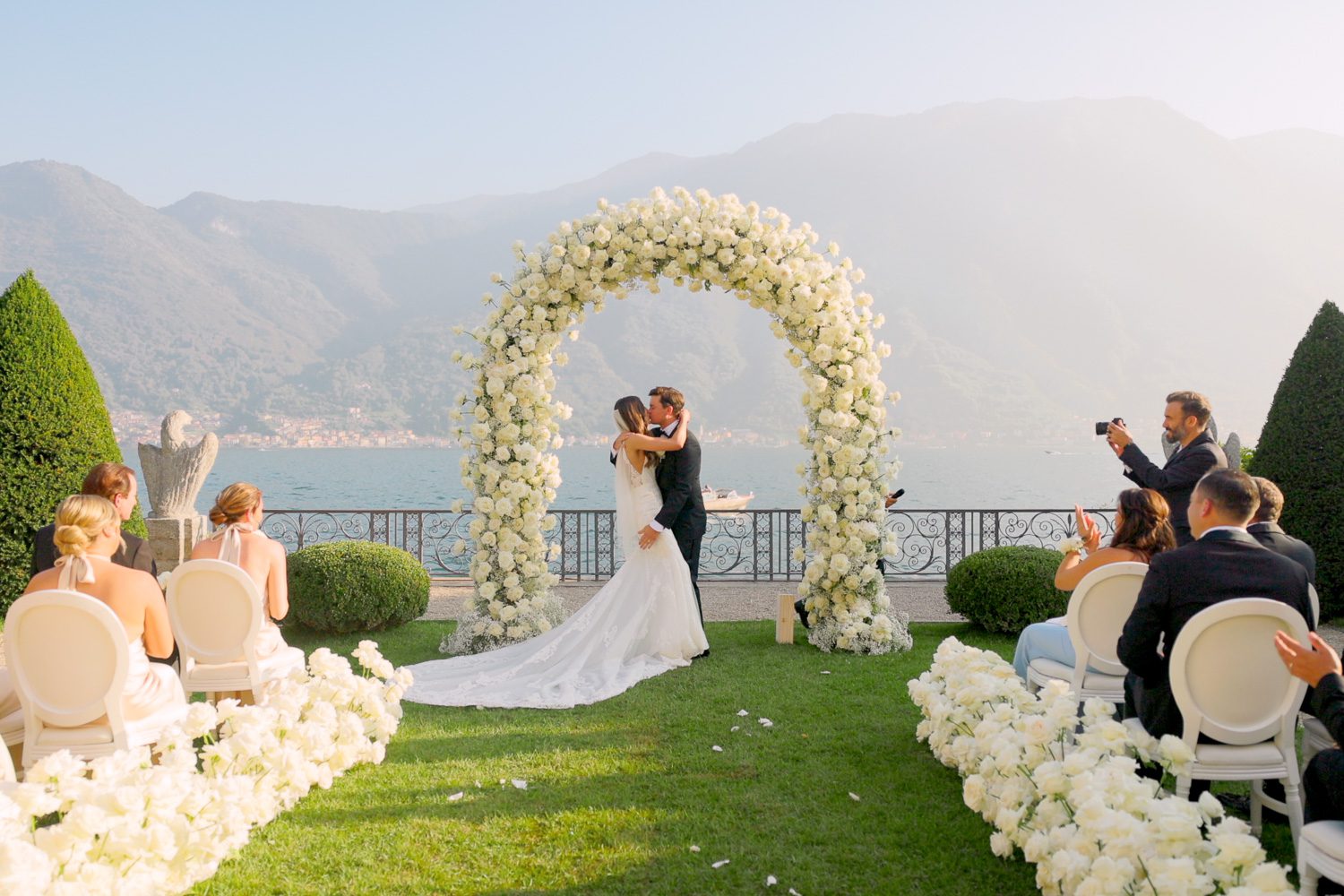 Bride and groom share their first kiss during the wedding ceremony at Villa Balbiano on Lake Como — captured by Koman Studio, fine-art wedding photographers in Italy.