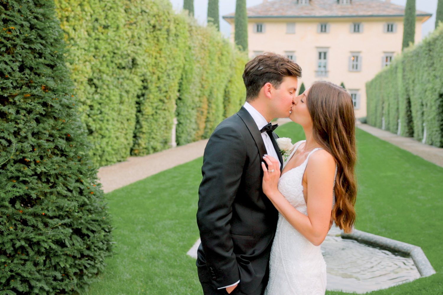 Bride and groom share an epic kiss in front of Villa Balbiano on Lake Como — captured by Koman Studio, fine-art wedding photographers and filmmakers in Italy.