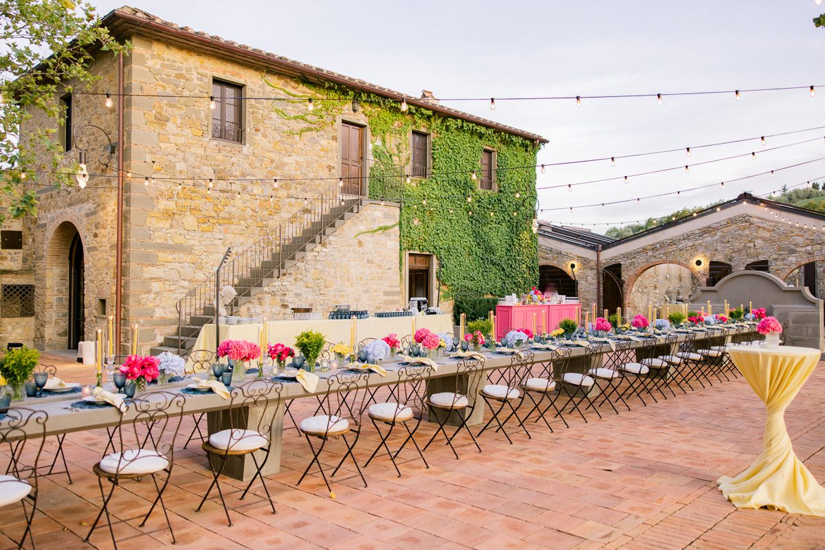 Elegant welcome dinner table setup at Borgo di Vignamaggio in Tuscany with candles and rustic Italian details