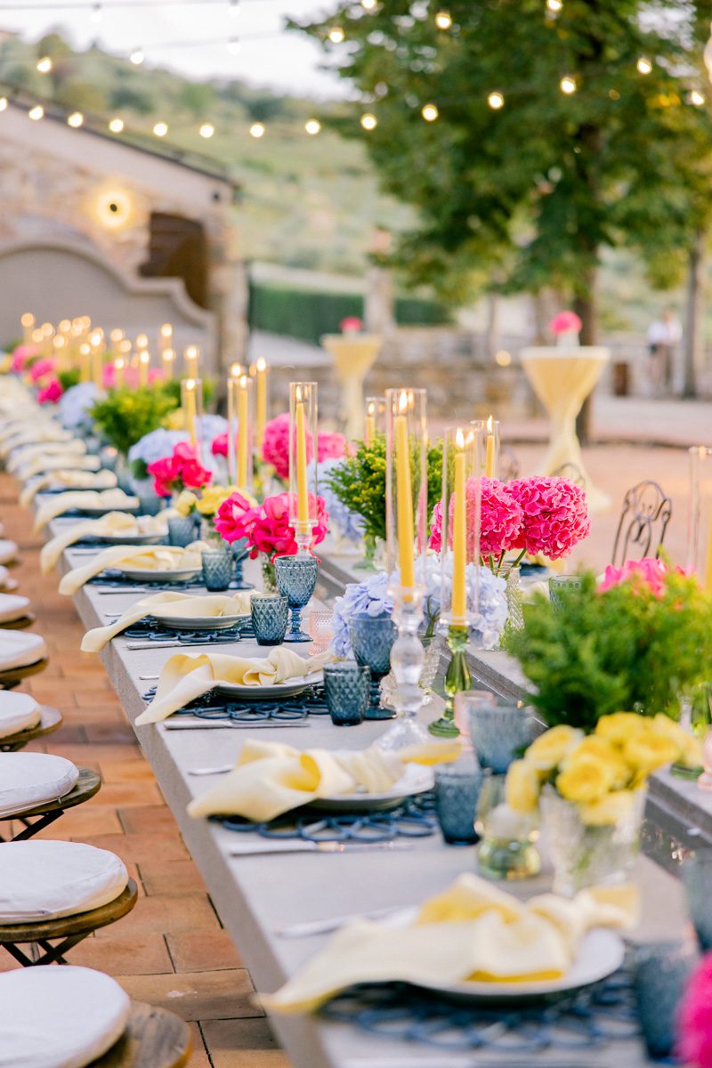 Close-up detail of the welcome dinner table at Borgo di Vignamaggio in Tuscany featuring candlelight, natural linens, and rustic Italian tableware