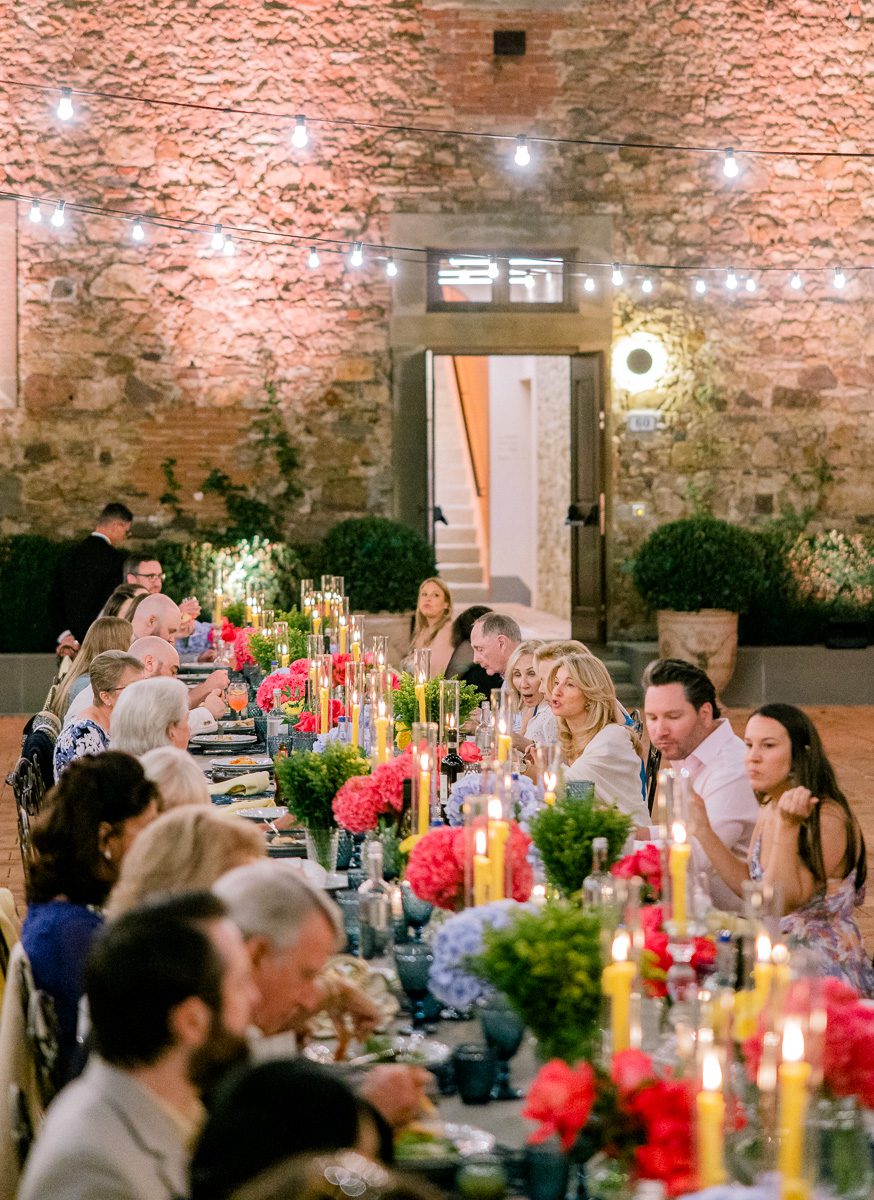 Atmosphere during the welcome dinner at Borgo di Vignamaggio in Tuscany with guests dining under warm string lights