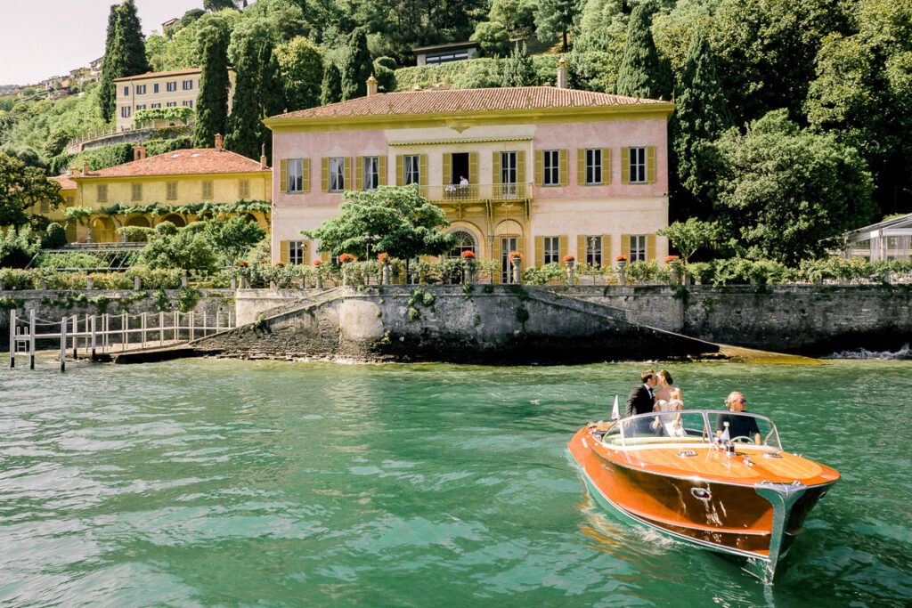Bride and groom on a classic wooden boat on Lake Como during their Villa Pizzo wedding
