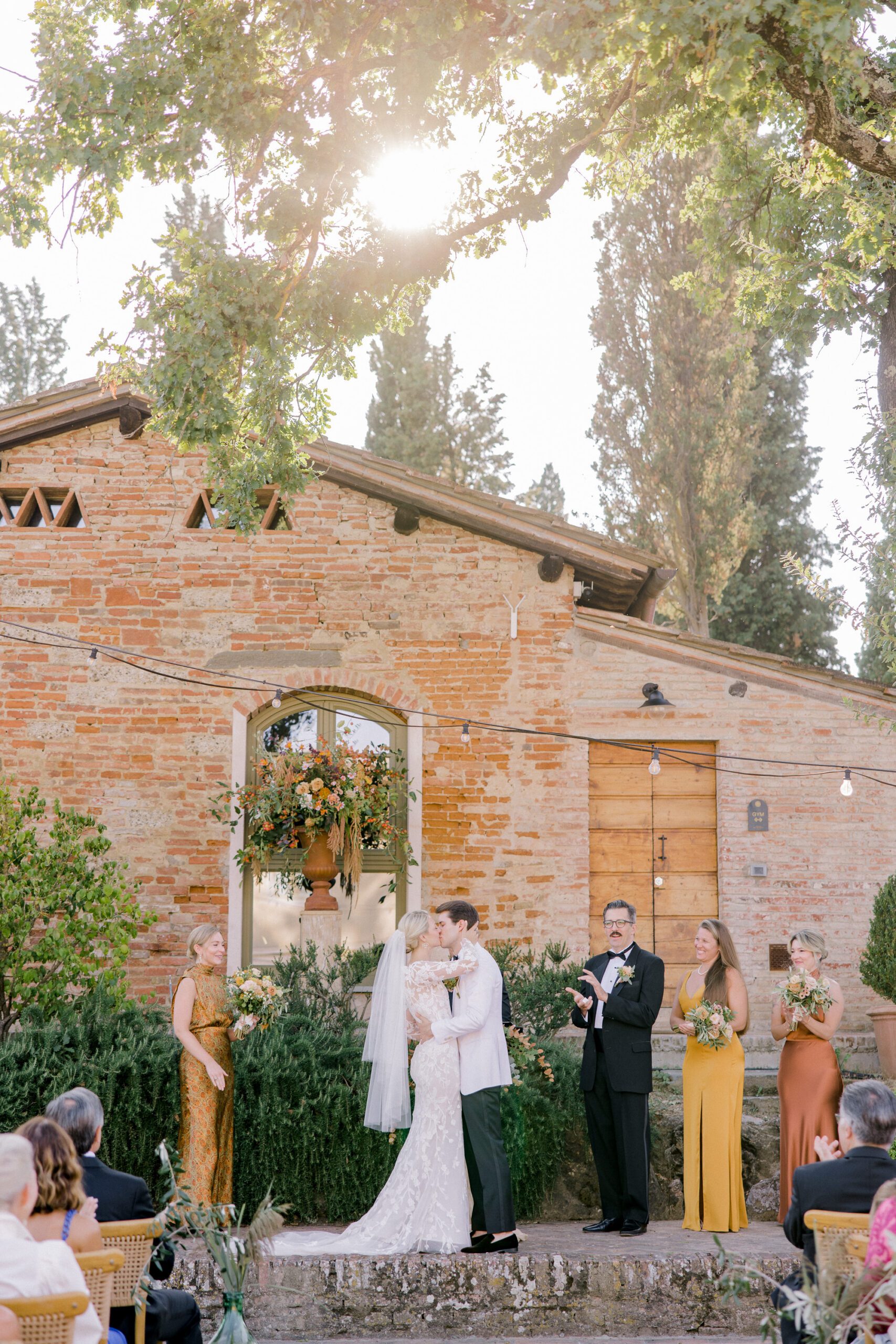 Romantic outdoor wedding ceremony at Villa Petriolo in Tuscany with golden autumn light, heartfelt vows