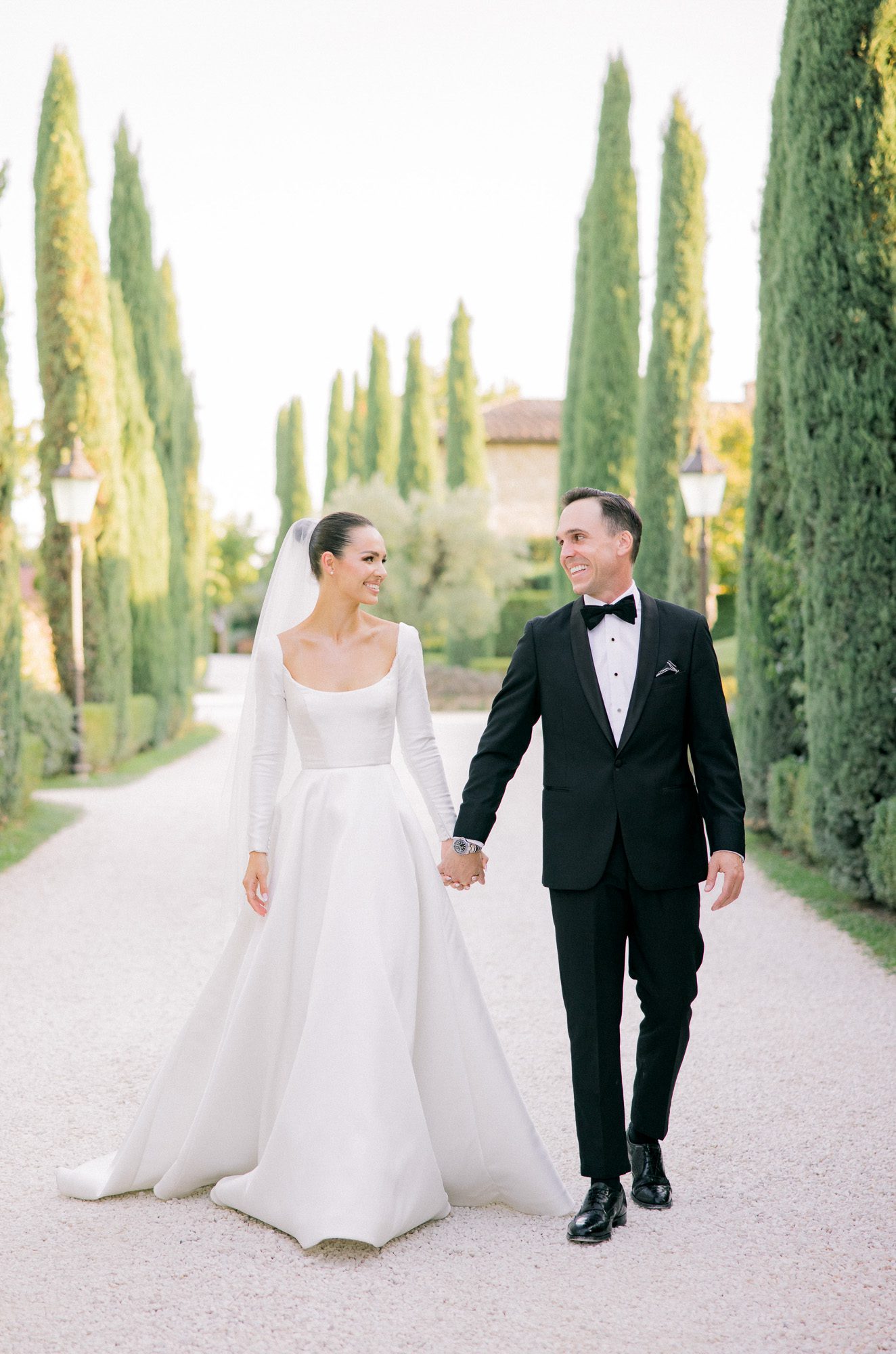 Newlyweds walking through Borgo Santo Pietro gardens after Tuscany elopement ceremony